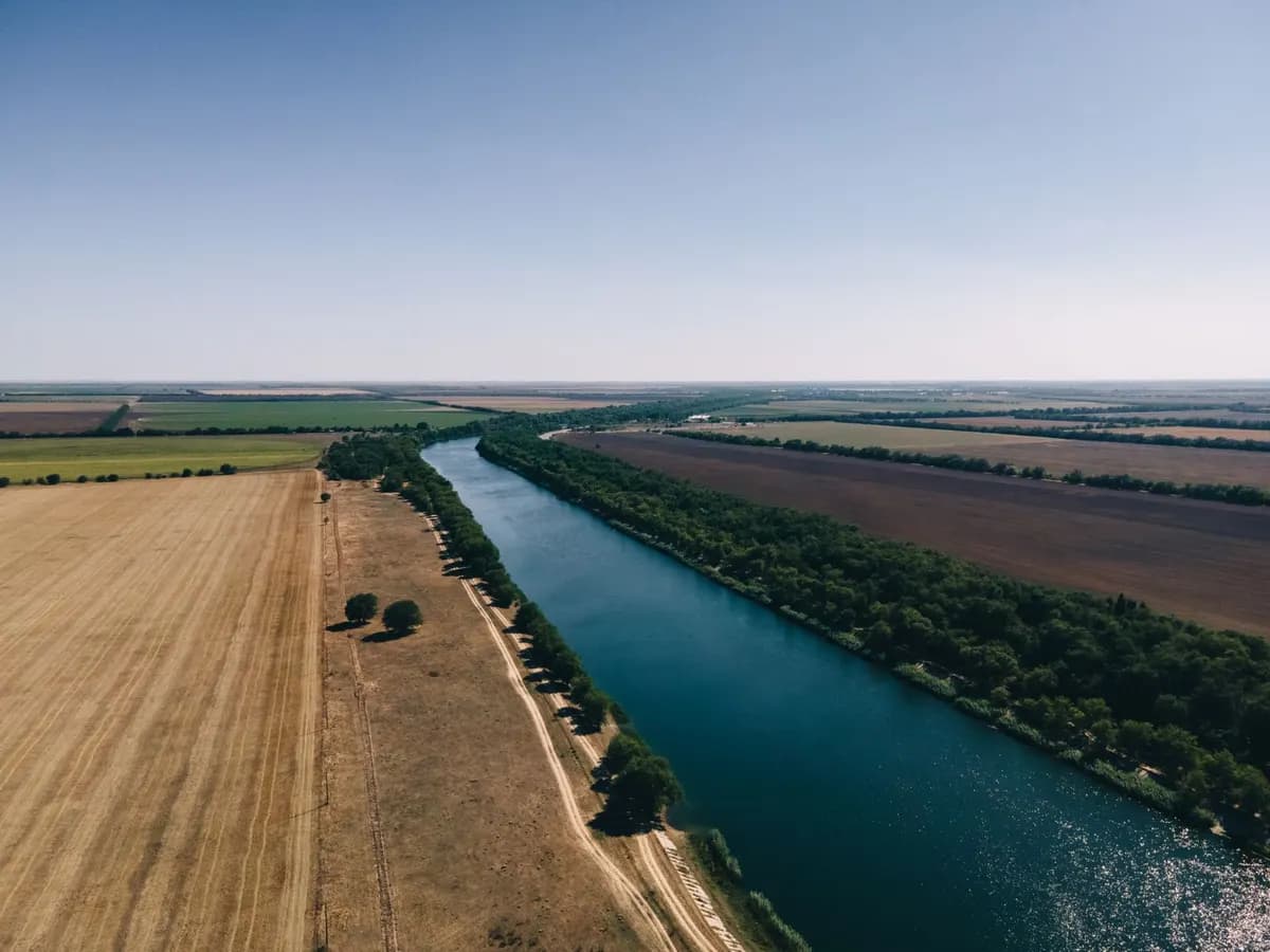 A wide river running between farm fields, seen from above