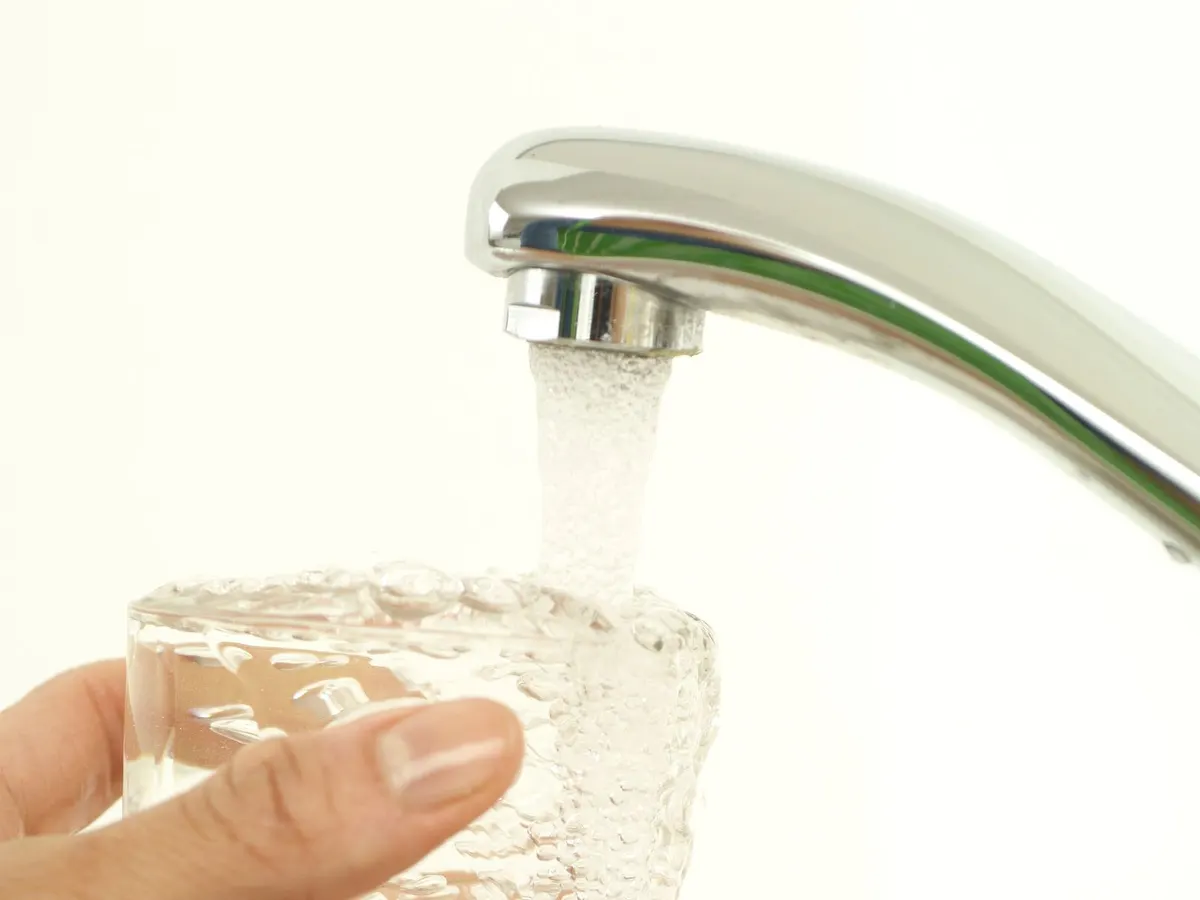 A glass being filled with drinking water from a kitchen tap